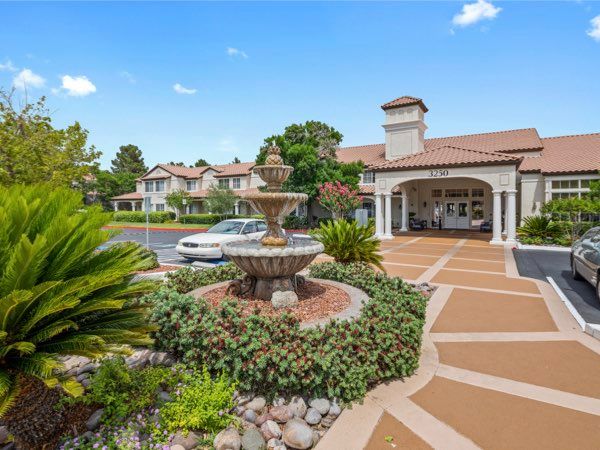 A beautifully landscaped residential area featuring a fountain and stylish architecture.