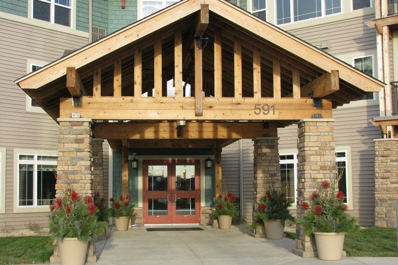 A building entrance with wooden beams and decorative plants.