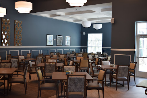 A spacious dining area featuring modern furniture and blue walls, ready to welcome guests.