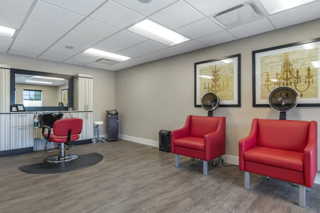 A modern hair salon with red chairs and a stylish interior.