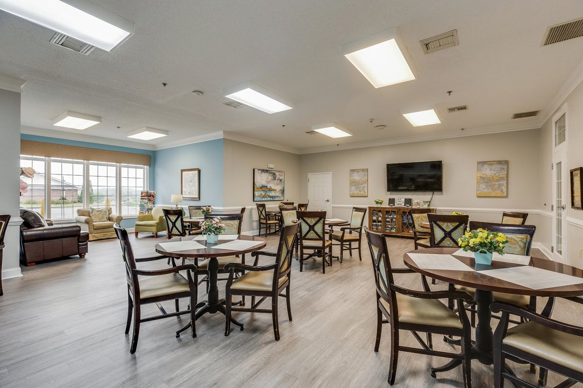 A spacious dining area with tables and chairs, featuring bright lighting and a cozy atmosphere.