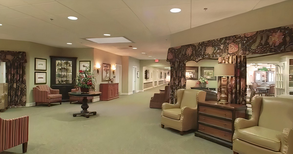 A well-decorated lobby area with armchairs, artwork on the walls, and a long hallway.