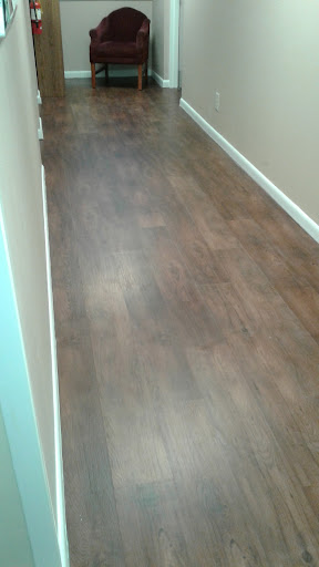 A view of a hallway with wooden flooring.