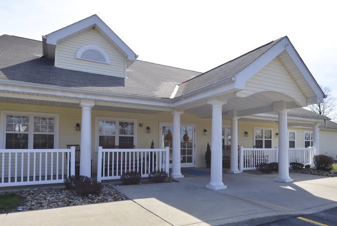 A residential house with a covered porch and prominent columns.
