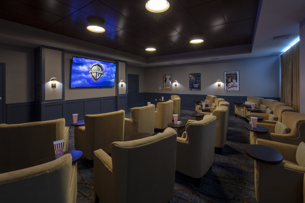 A luxurious home theater with comfortable seating facing a large screen.