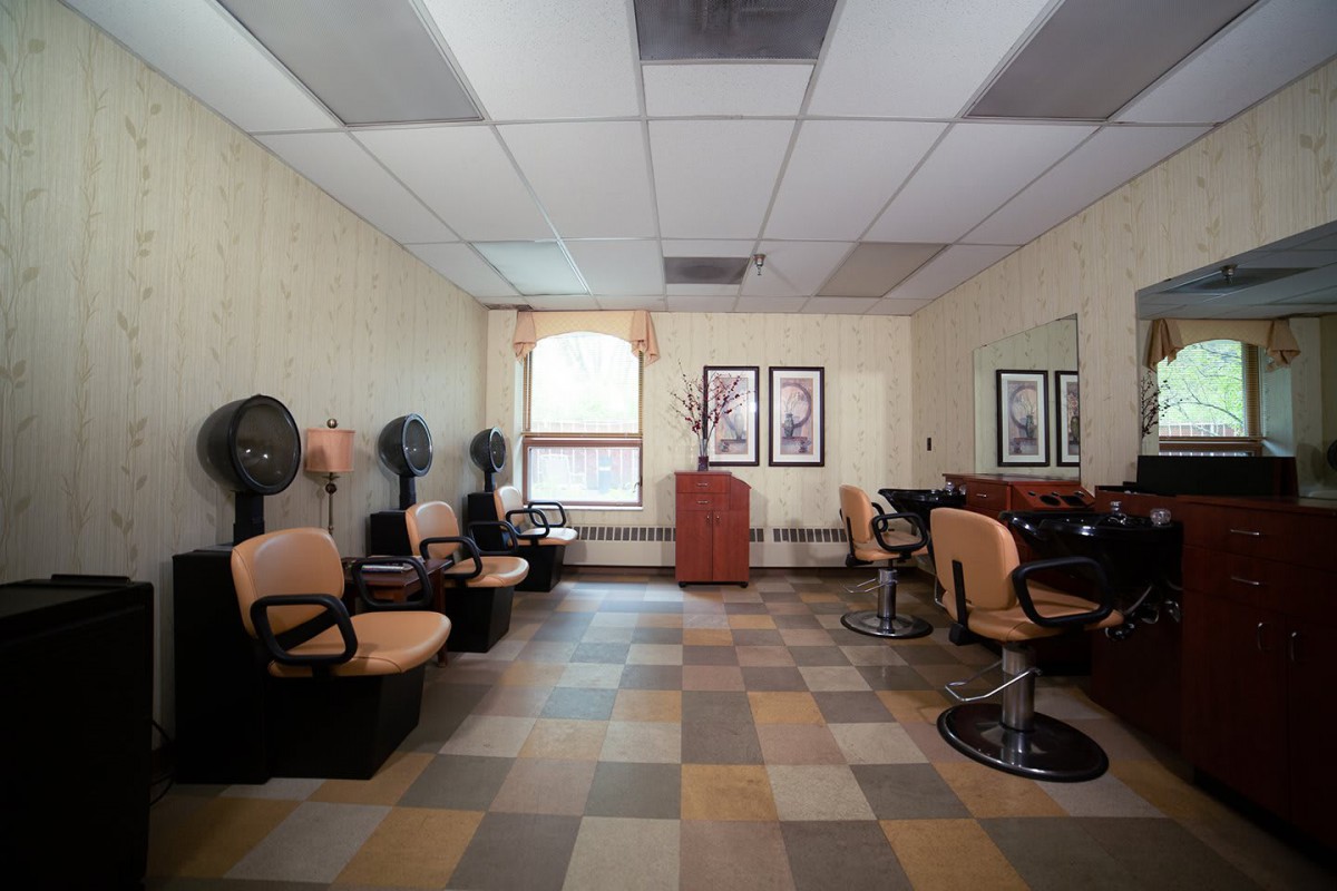 A vintage-style hair salon with chairs, hair dryers, and mirrors.