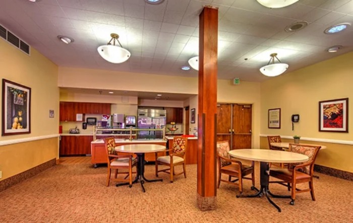 A cozy restaurant interior featuring tables and chairs with wooden accents.