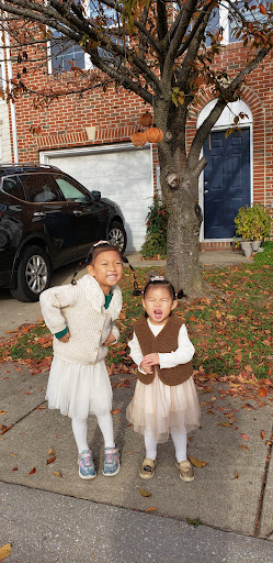 Two joyful children enjoying a sunny fall day outside their home.