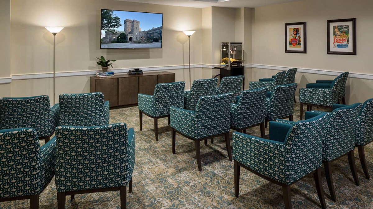 A small meeting room with arranged seating facing a television.