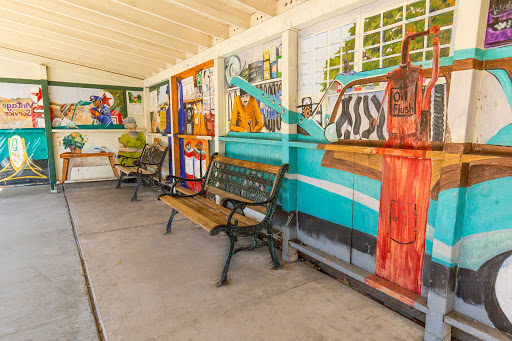 A vibrant community space featuring colorful murals and benches for relaxation.