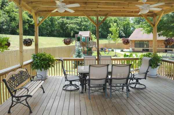 A cozy outdoor patio with seating and a view of the backyard.