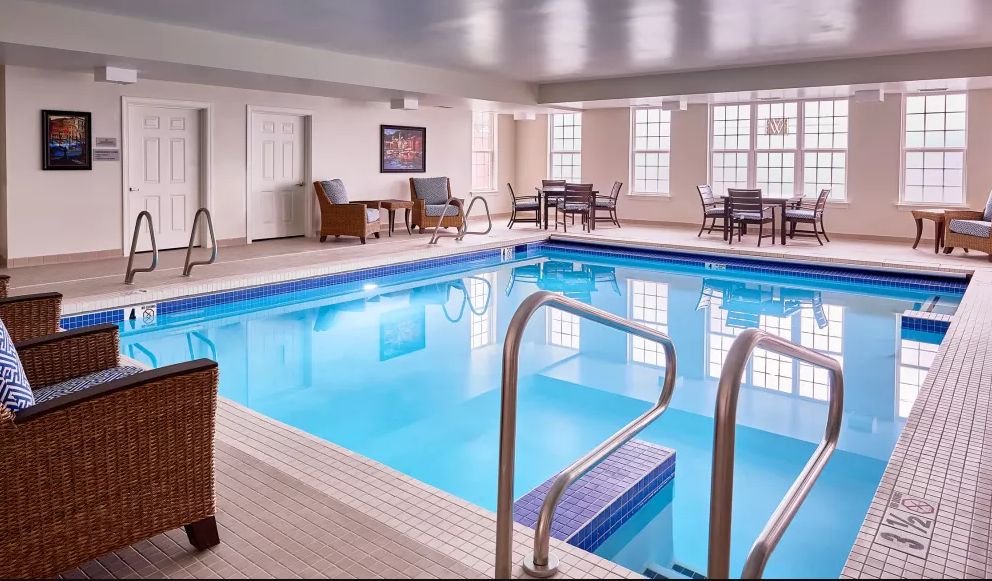 An inviting indoor swimming pool with seating arrangements for relaxation.
