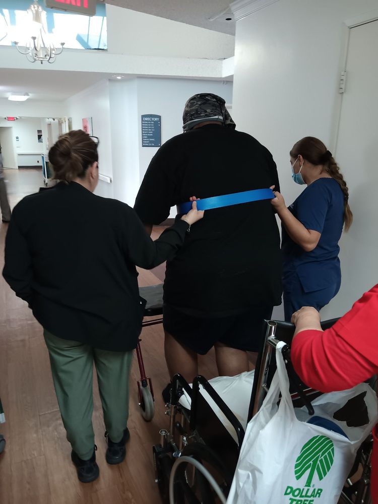 Healthcare professionals assist a patient in rehabilitation exercises.