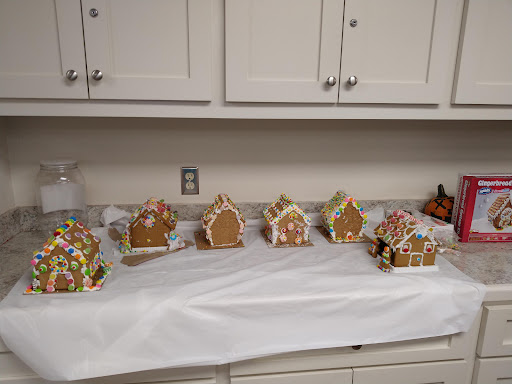 A display of beautifully decorated gingerbread houses arranged on a table in a kitchen.
