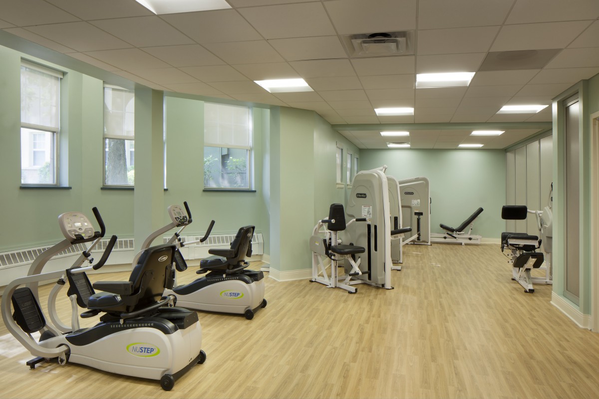 A well-lit gym with various exercise machines and equipment.