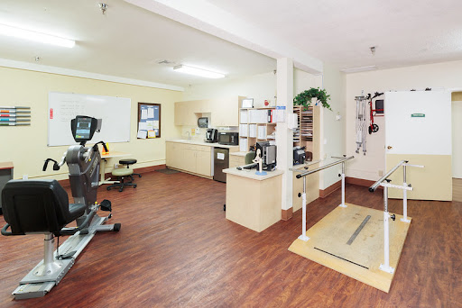A well-equipped rehabilitation room featuring exercise equipment and therapy aids, designed for physical therapy sessions.