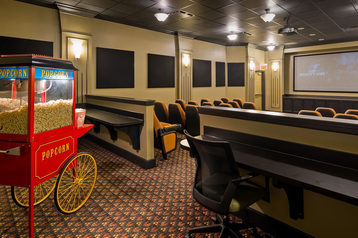 A cozy home theater setup with a vintage popcorn machine and comfortable seating.