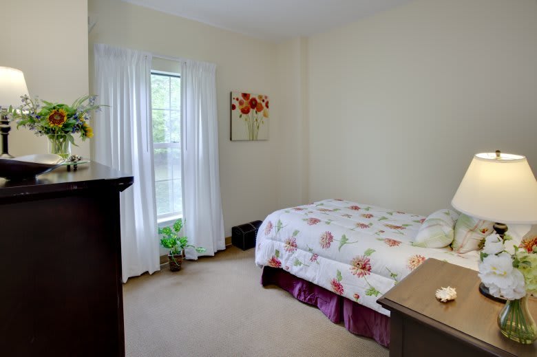 A cozy bedroom with a bed, window, and decorative elements.