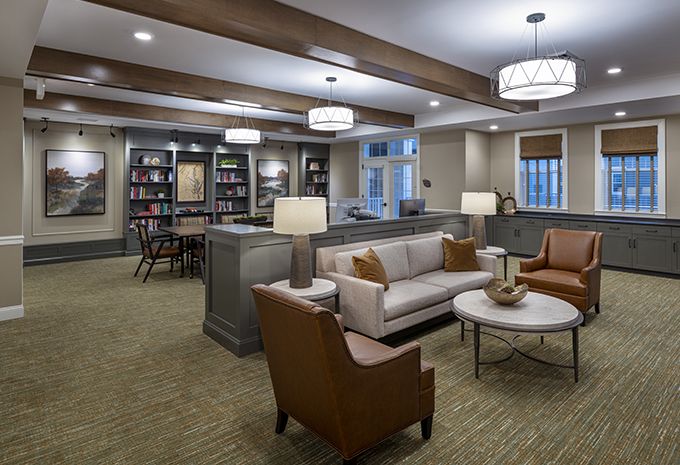 A modern living room with comfortable seating, bookshelves, and elegant lighting.