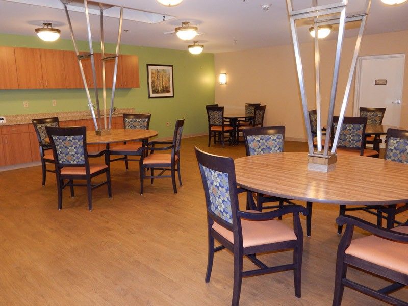 A modern dining room with multiple tables and chairs, featuring stylish lighting and decor.