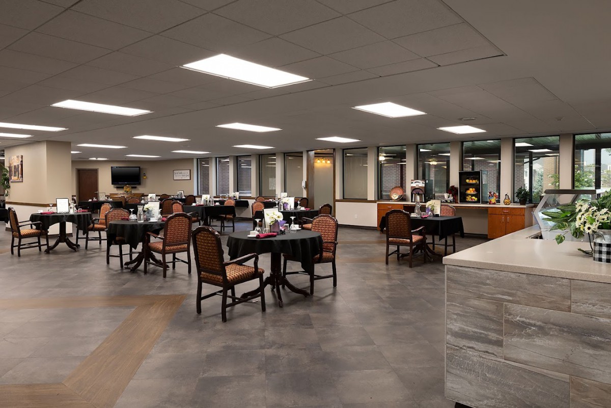 An empty dining area with tables and chairs arranged in a well-lit room.