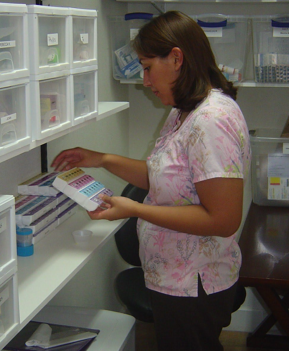A nurse organizing medical supplies in a storage room.