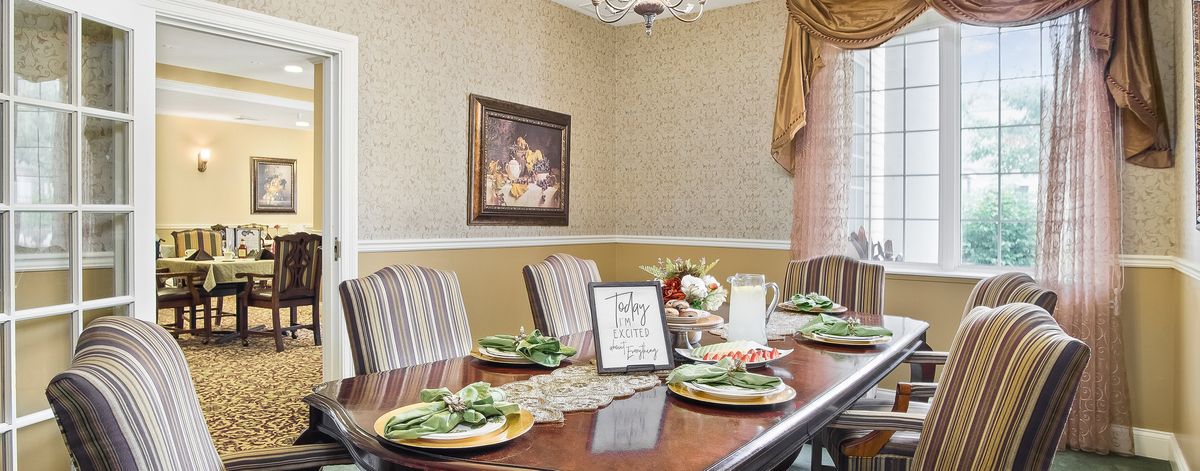 A well-decorated dining room with a formal table setting and elegant decor.