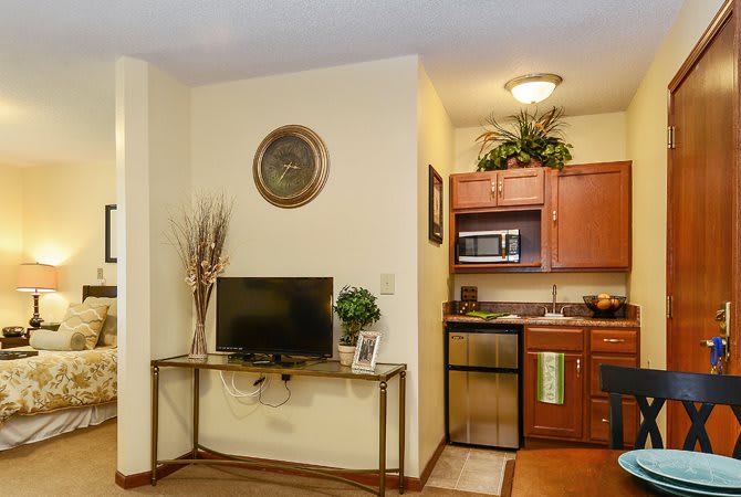 A cozy living space with a small kitchenette and a television.