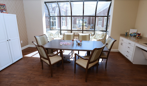 A well-lit conference room featuring a large table surrounded by chairs, ideal for meetings and collaborations.