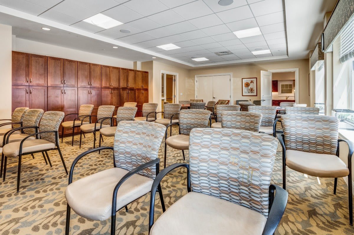 An empty conference room with rows of chairs arranged for a meeting.