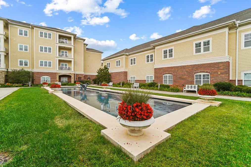 A well-maintained apartment complex with a central swimming pool and landscaped garden.