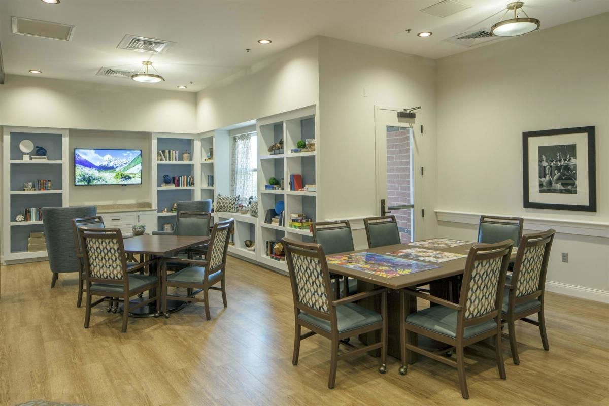 A well-lit room with tables, chairs, and shelves featuring decorative items.