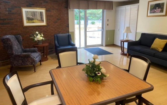 A cozy living space with comfortable seating and a central table adorned with a floral arrangement.