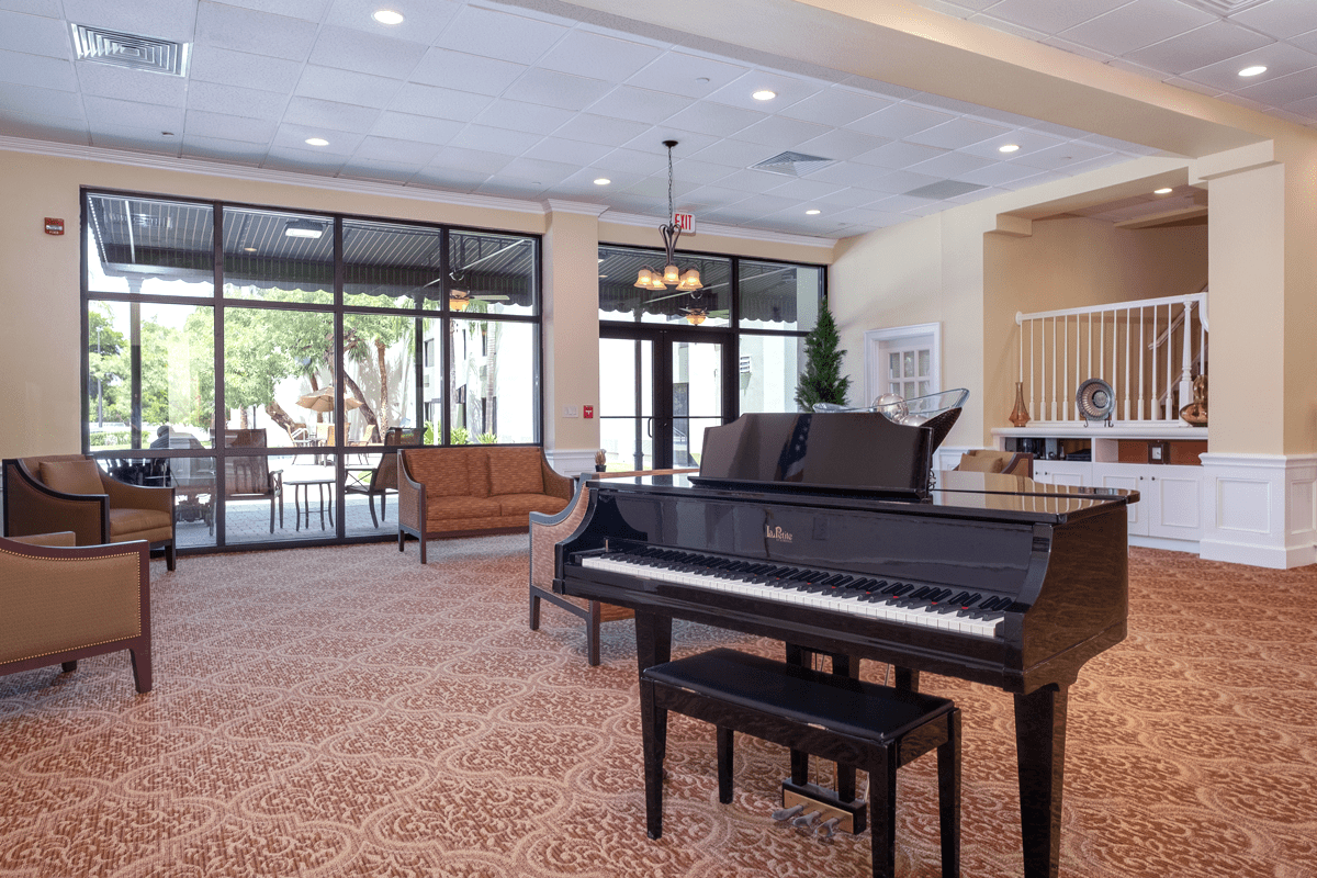 A spacious lobby with a grand piano and elegant furnishings.