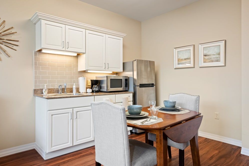 A cozy kitchen and dining area with modern appliances and a neatly set table.