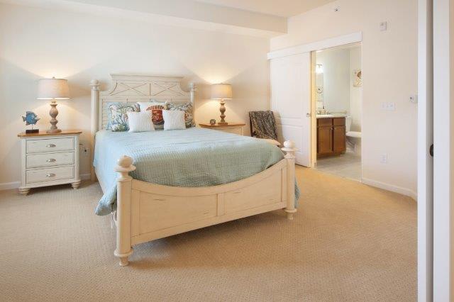 A cozy and well-decorated bedroom with a large bed, stylish furniture, and an adjoining bathroom.