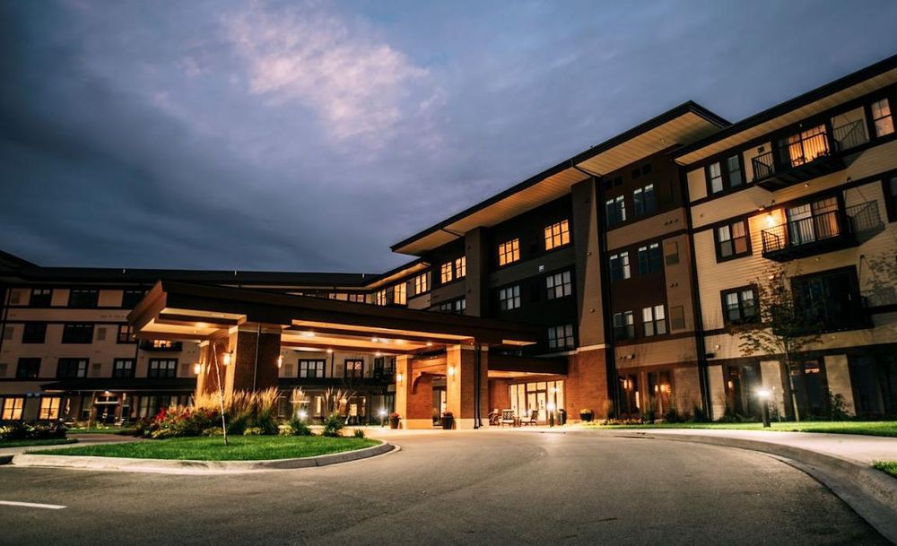A well-lit hotel building at night under a cloudy sky.