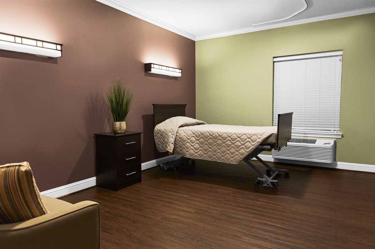 A modern, minimalist room with a hospital bed and simple decor.