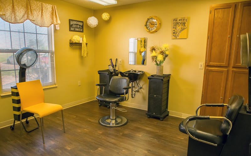 A bright and cozy hair salon with yellow walls and stylish decor.