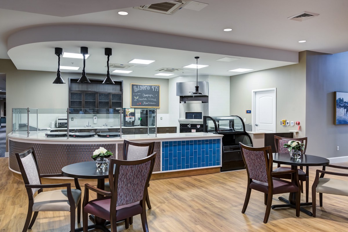 A modern cafe interior with tables and chairs, featuring a sleek design and bright lighting.