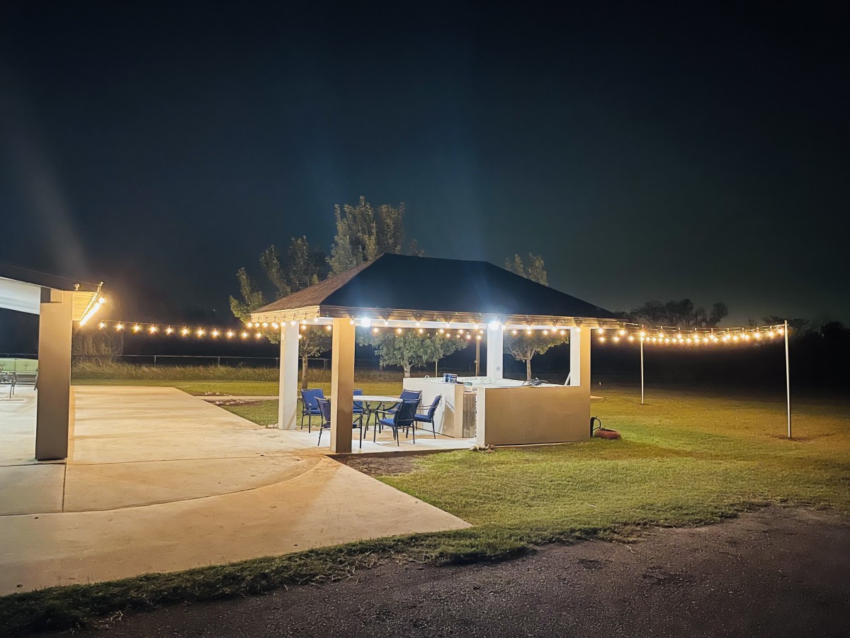 A cozy gazebo illuminated by string lights on a quiet night.