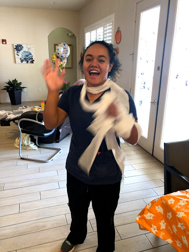A joyful moment captured as someone waves enthusiastically in a lively indoor setting.