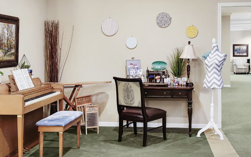 A cozy home office setup with a desk, chair, and decorative wall plates.