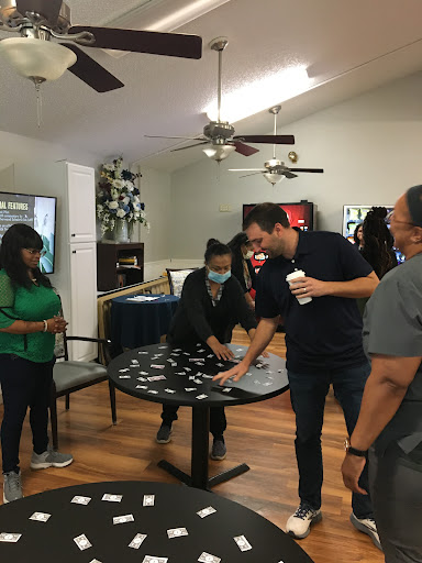 A group of people engaged in a fun activity around a table, showcasing camaraderie and teamwork.