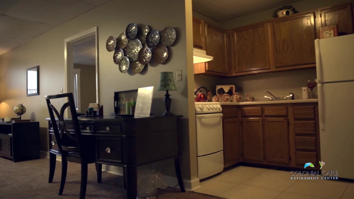 A cozy interior featuring a kitchen area and a decorated living space with wall art.