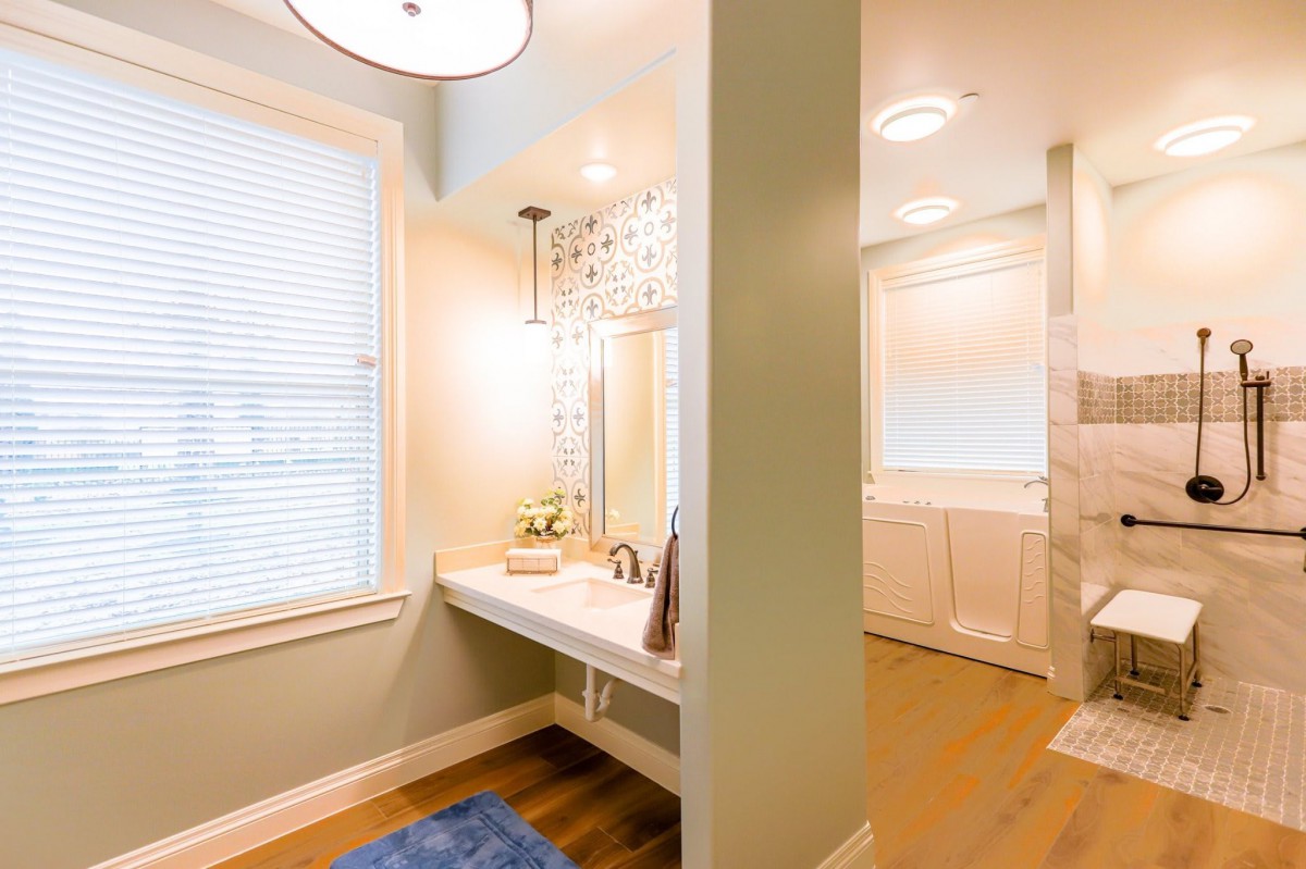 A modern bathroom with stylish lighting and wooden flooring.
