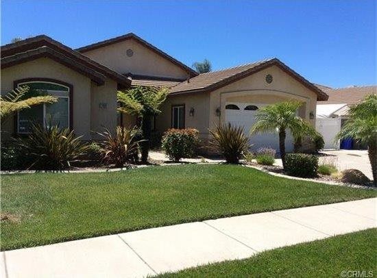 A suburban house with a well-maintained lawn and palm trees.