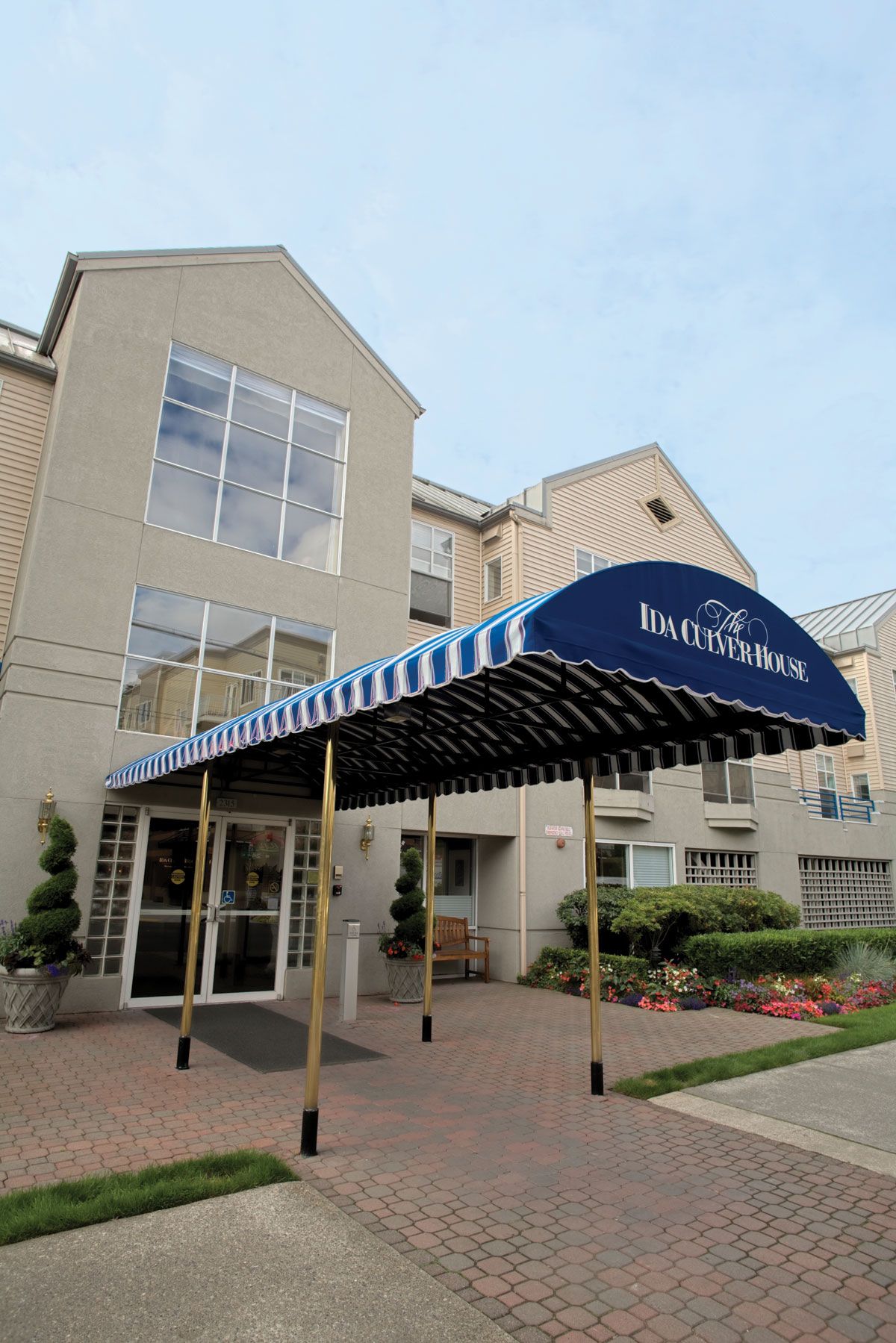 The entrance of a hotel with a blue awning.