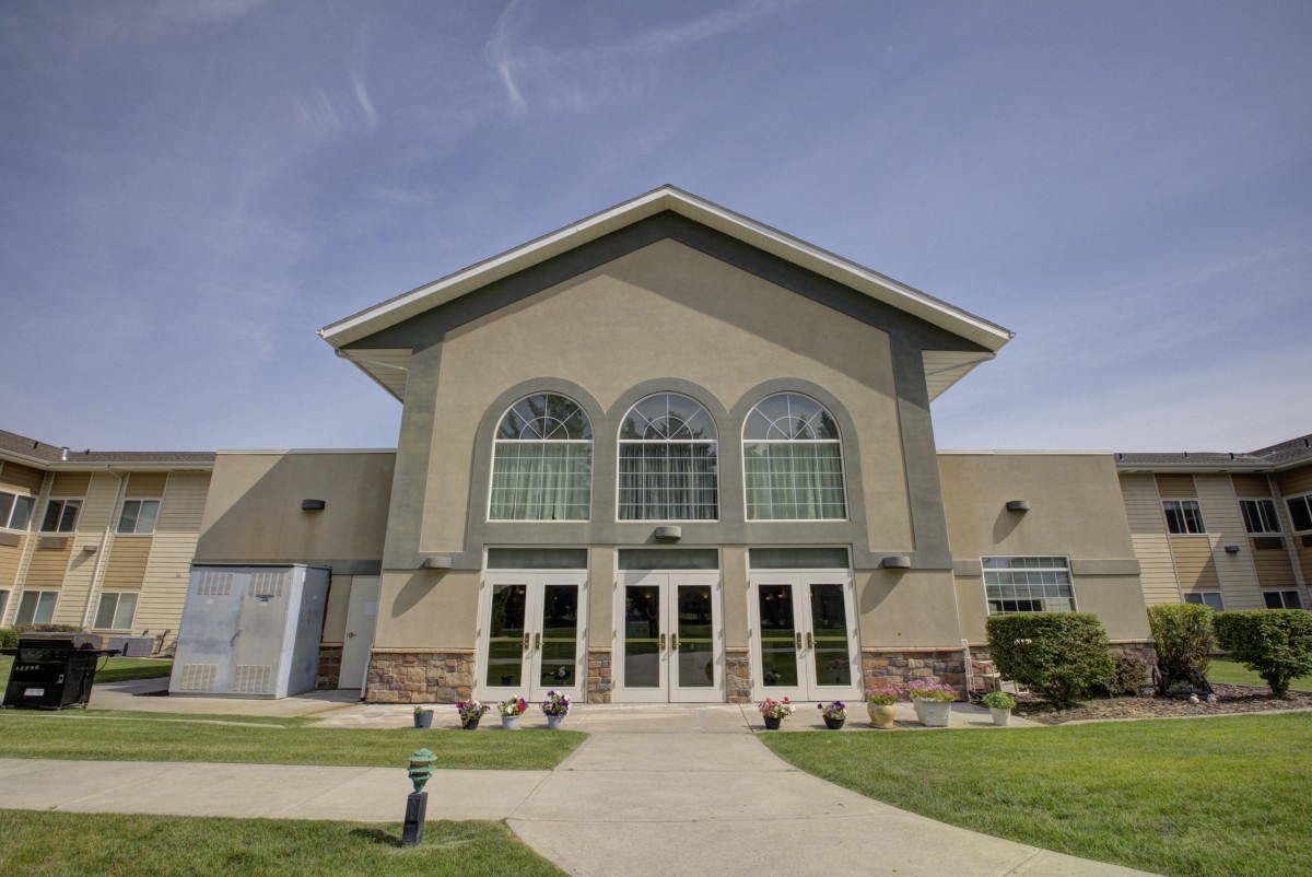A modern building with large arched windows under a clear blue sky.
