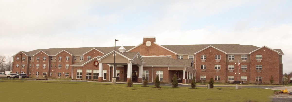 A large brick building with a clock tower and well-maintained grounds.